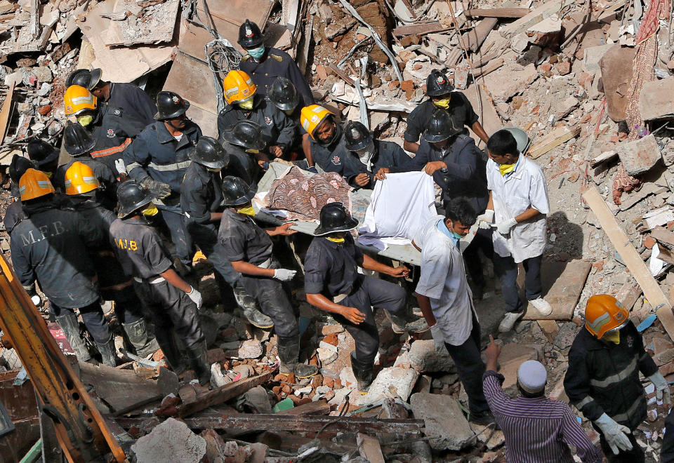 <p>Firefighters carry the body of a victim from the site of a collapsed building in Mumbai, India, August 31, 2017. (Photo: Shailesh Andrade/Reuters) </p>