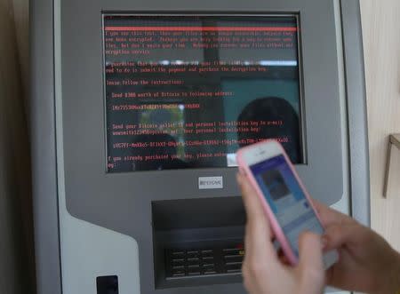 FILE PHOTO: A message demanding money is seen on a monitor of a payment terminal at a branch of Ukraine's state-owned bank Oschadbank after Ukrainian institutions were hit by a wave of cyber attacks, in Kiev, Ukraine, June 27, 2017. REUTERS/Valentyn Ogirenko