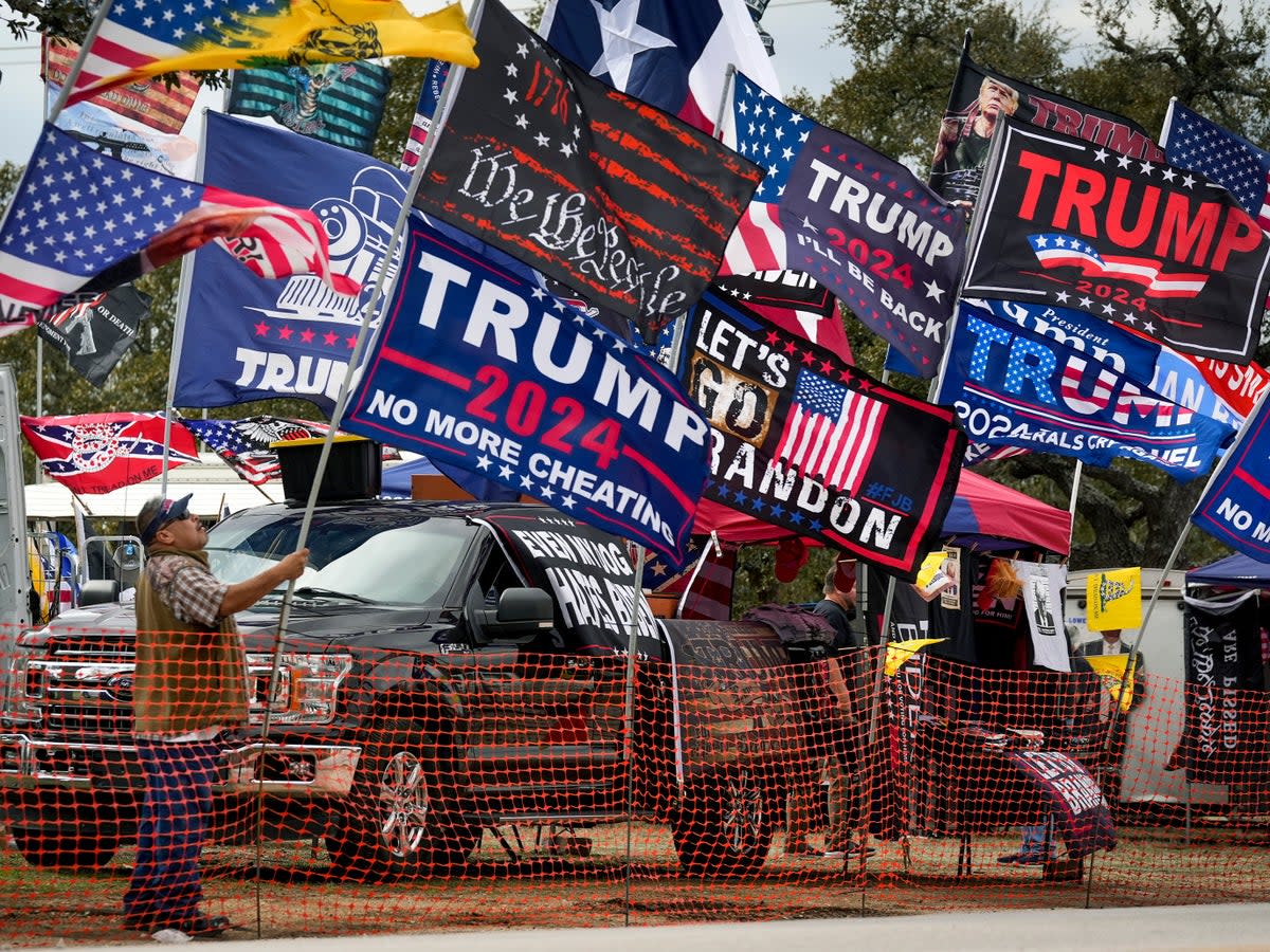 Rudy Martinez, of San Antonio, sets up his flags for sale at the Take Our Border Back Convoy in Dripping Springs, Texas, on Thursday (AP)