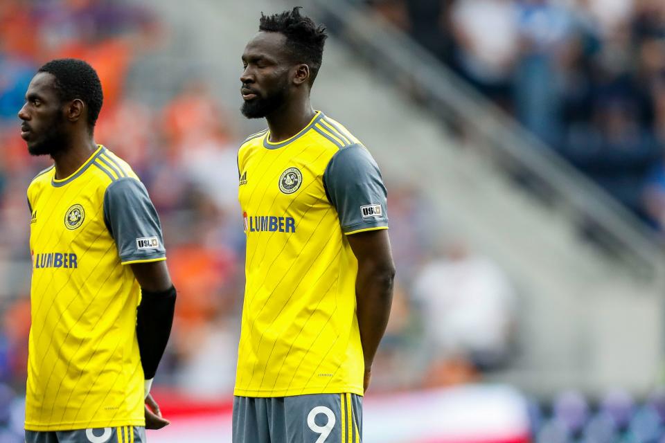 Then-Pittsburgh Riverhounds SC forward Albert Dikwa stands during the national anthem before a game in Cincinnati in June.