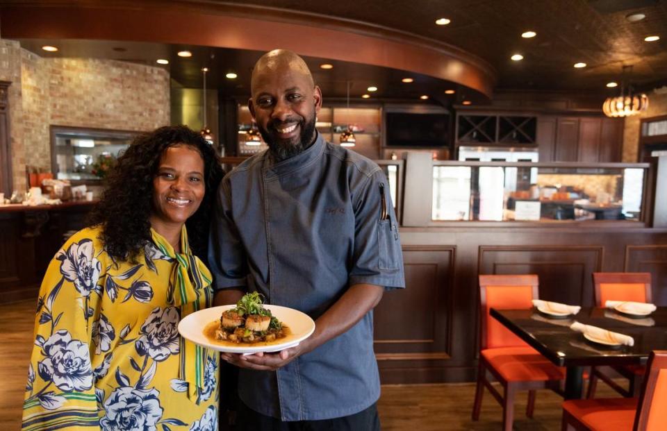 Quentin “Chef Q” Bennett holds his pan seared scallops as he stands with general manager and wife, Tamara Bennett at Q1227 restaurant in Roseville in 2022.