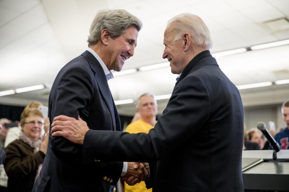 Democratic presidential candidate former Vice President Joe Biden smiles as former Secretary of State John Kerry, left, takes the podium to speak at a campaign stop at the South Slope Community Center, Saturday, Feb. 1, 2020, in North Liberty, Iowa. (AP Photo/Andrew Harnik)