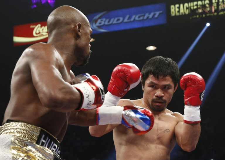 Floyd Mayweather Jr (L) measures Manny Pacquiao (R) during their welterweight unification bout on May 2, 2015 at the MGM Grand Garden Arena in Las Vegas, Nevada