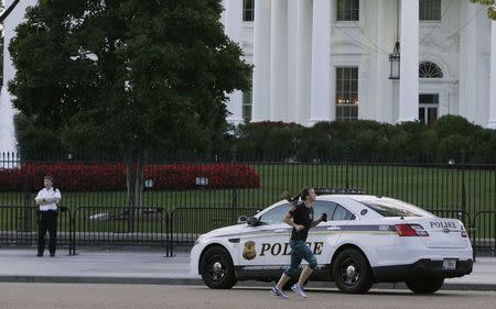 A United States uniformed Secret Service officer (L) is seen at a post in front of the White House in Washington September 23, 2014. REUTERS/Gary Cameron