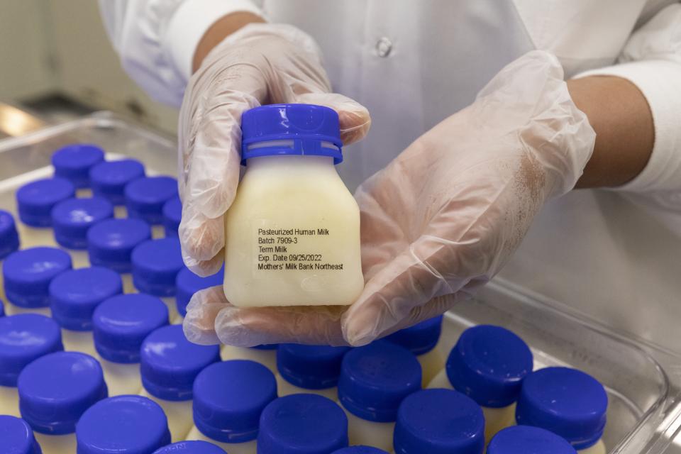 Lab manager Shantel Collins holds a pasteurized container of breast milk at Mothers' Milk Bank of the Northeast, Friday, May 13, 2022, in Newton, Mass. (AP Photo/Michael Dwyer)