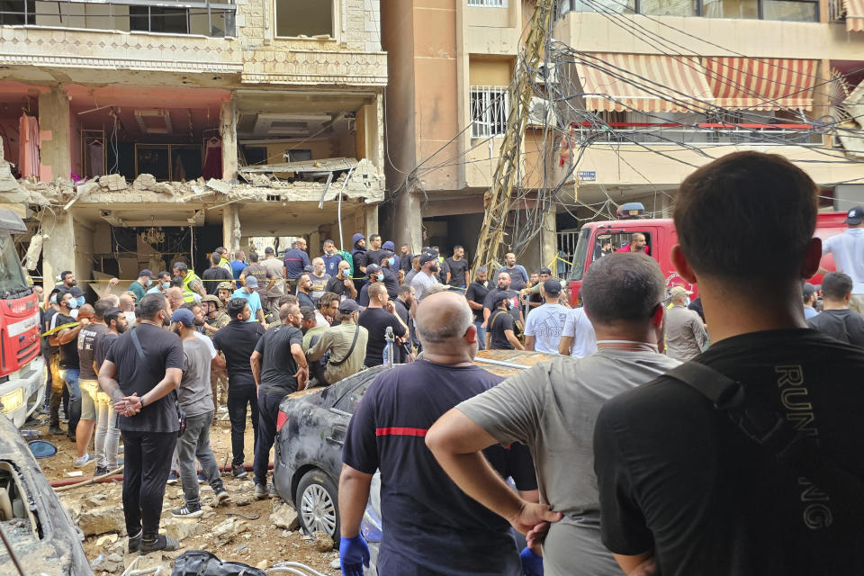 Residents look on as rescuers arrive at the scene of an Israeli missile strike in the southern suburbs of Beirut, Friday, Sept. 20, 2024. (AP Photo/Hassan Ammar)