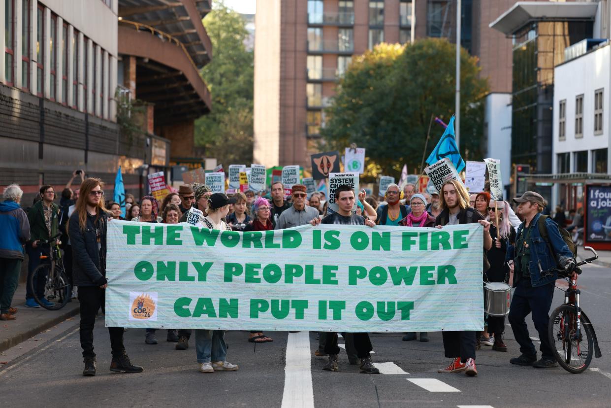 Demonstrators holding a banner and placards march towards the city center during the rally in Bristol, UK on November 12, 2022.