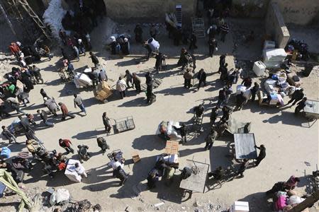 A view of people walking at the Karaj al-Hajez crossing, a passageway separating Aleppo's Bustan al-Qasr, which is under the rebels' control and Al-Masharqa neighbourhood, an area controlled by the regime February 9, 2014. REUTERS/Hosam Katan