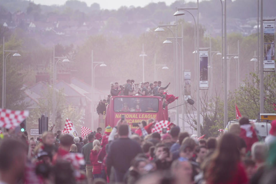 Members of the Wrexham FC soccer team ride on an open top bus as they celebrate promotion to the Football League in Wrexham, Wales, Tuesday, May 2, 2023. (AP Photo/Jon Super)