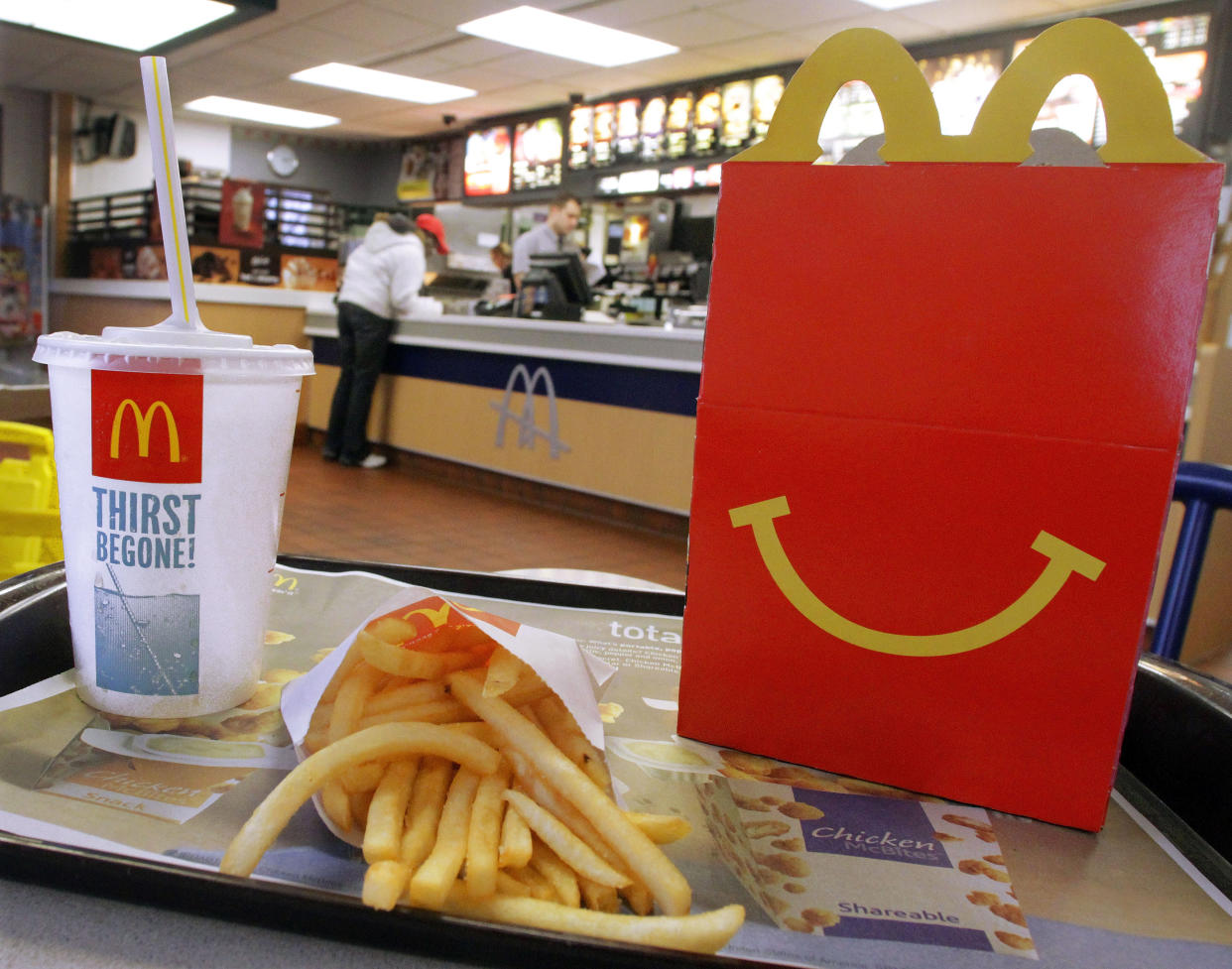 In this Jan. 20, 2012 photo, the McDonald's logo and a Happy Meal box with french fries and a drink are posed at McDonald's, in Springfield, Ill.  McDonald’s Corp. saw net income jump by 11 percent in the fourth quarter, as the fast-food giant continued to attract budget-conscious customers with low prices.  (AP Photo/Seth Perlman)