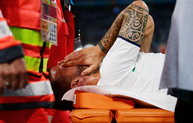 Italy’s Leonardo Spinazzola covers his face as he is carried off on a stretcher