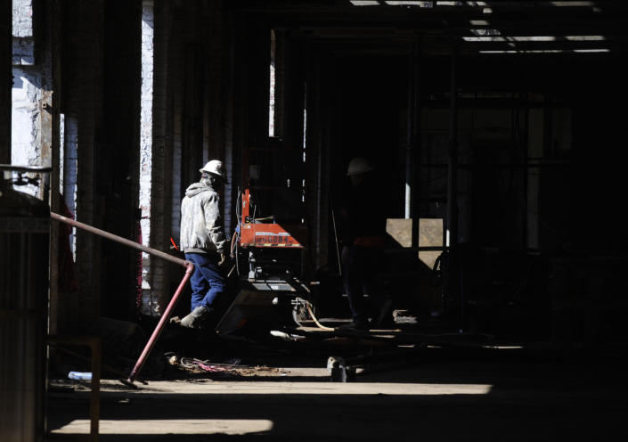 A construction crew member enters a once-abandoned cotton gin factory that is being renovated into apartments in Prattville, Ala., on Friday, Jan 28, 2022. The factory's history is tied up in slavery, and the project demonstrates the difficulty of telling complicated U.S. history. (AP Photo/Jay Reeves)