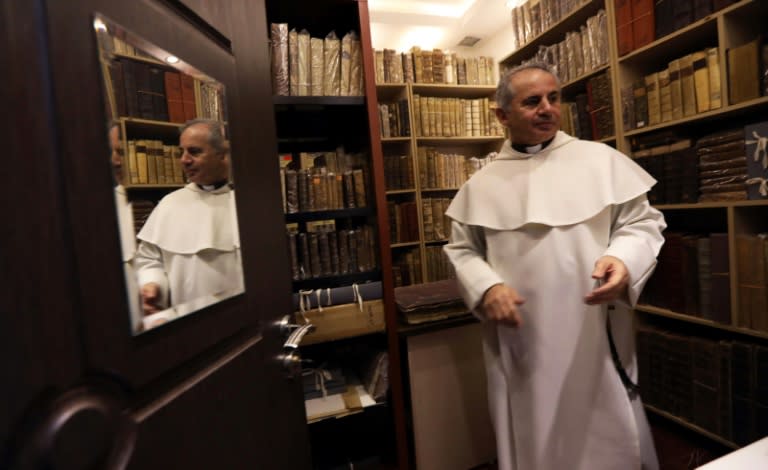 Father Najeeb Michael stands by old Christian books at the Oriental Manuscript Digitisation Centre (CNDO) in Arbil, the capital of Iraq's autonomous northern Kurdish region