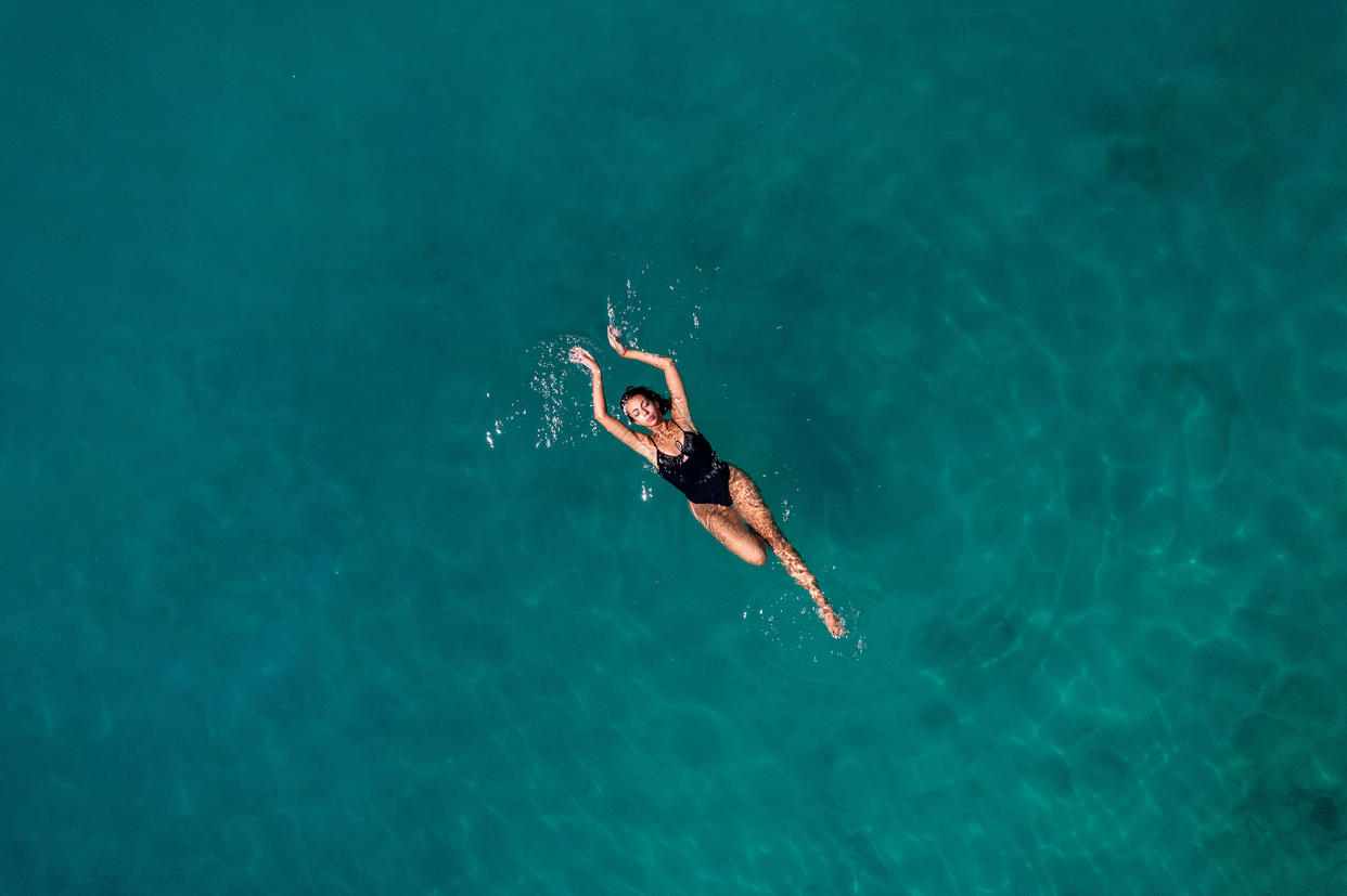 Aerial View Young Woman is Floating on Navy Blue Sea