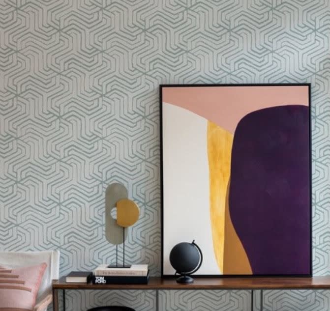 geometric blue wallpaper behind artwork and table