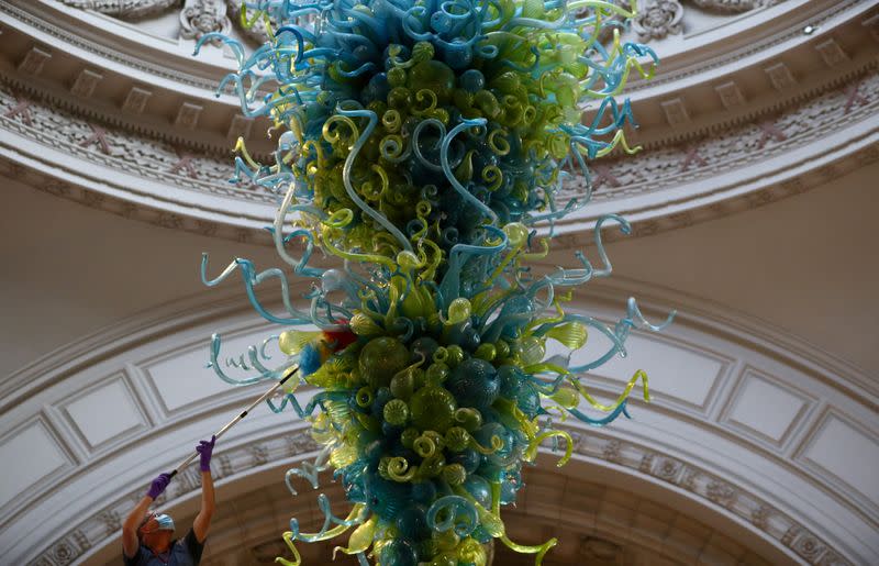 A museum technician cleans the V&A Rotunda Chandelier by Dale Chihuly during preparations to reopen the Victoria & Albert (V&A) Museum, in London