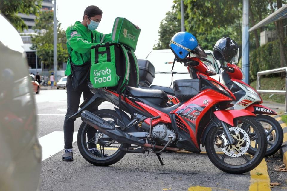 Food delivery rider Zaim Zafran, 21, is pictured at the Taman Tun Dr Ismail wet market May 6, 2020. — Picture by Ahmad Zamzahuri