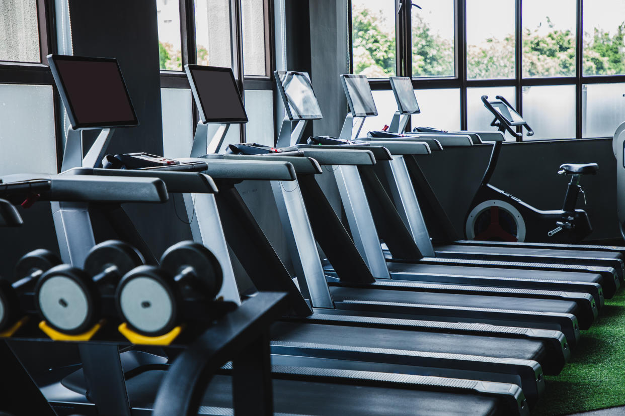 Five treadmills without people in a gym.