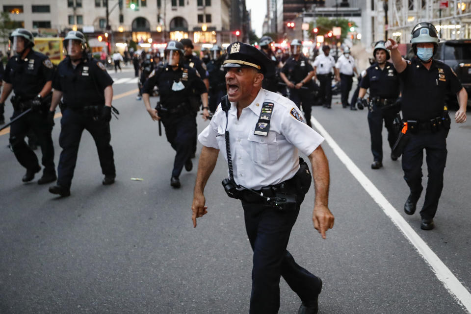 NYPD officers move in to arrest protesters for violating curfew beside the iconic Plaza Hotel on 59th Street, Wednesday, June 3, 2020, in the Manhattan borough of New York. Protests continued following the death of George Floyd, who died after being restrained by Minneapolis police officers on Memorial Day. (AP Photo/John Minchillo)