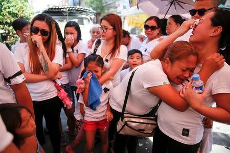 The wife and other relatives of Florjohn Cruz, who was killed in a police drugs buy-bust operation, cry as his coffin leaves their home for his funeral in Manila, Philippines October 30, 2016. REUTERS/Damir Sagolj/Files