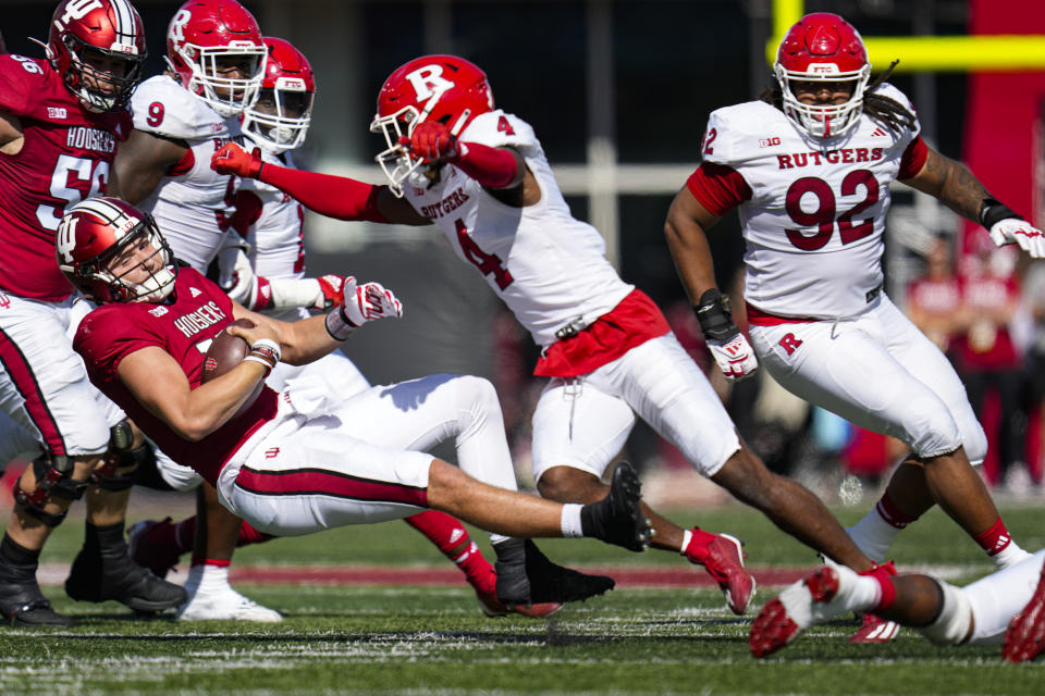 Indiana quarterback Brendan Sorsby (15) is tackled by Rutgers defensive back Desmond Igbinosun (4) during the first half of an NCAA college football game in Bloomington, Ind., Saturday, Oct. 21, 2023. (AP Photo/Michael Conroy)