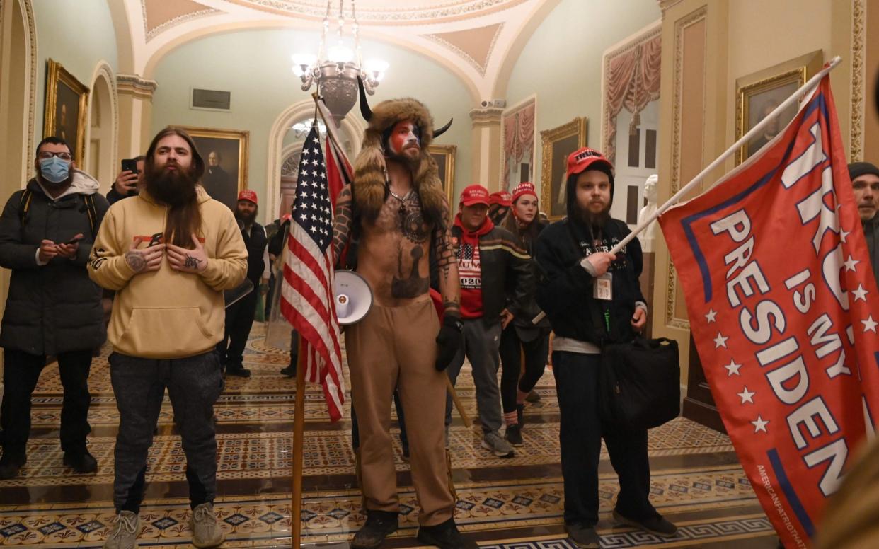 The 'QAnon Shaman' Jake Angelli was one of hundreds of protesters who broke into the Capitol - AFP