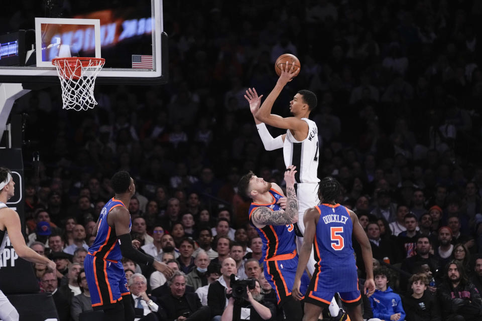 San Antonio Spurs' Victor Wembanyama, top right, shoots over New York Knicks defenders during the second half of an NBA basketball game, Wednesday, Nov. 8, 2023, in New York. The Knicks defeated the Spurs 126-105. (AP Photo/Seth Wenig)