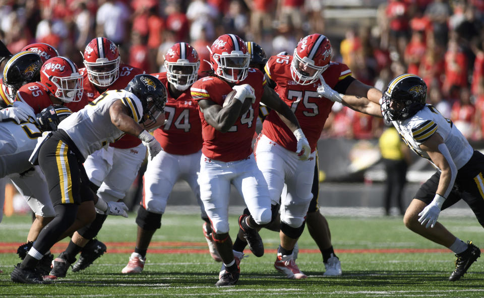 Maryland running back Roman Hemby (24) carries as Towson linebacker Mason Woods (55) and defensive back Evan Rutkowski pursue during the first half of an NCAA college football game Saturday, Sept. 2, 2023, in College Park, Md. (AP Photo/Steve Ruark)