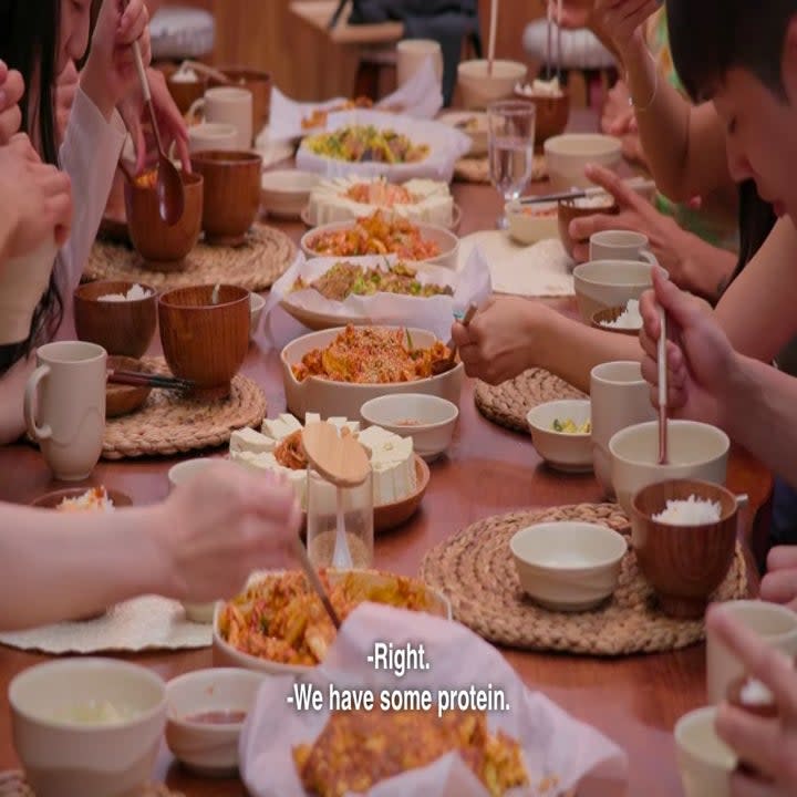 A table full of food including rice, kimchi, tofu, egg soup, and pajeon