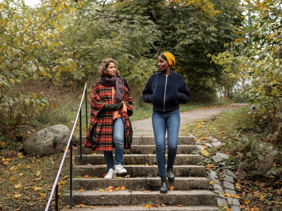 Two women walking down stairs in a park