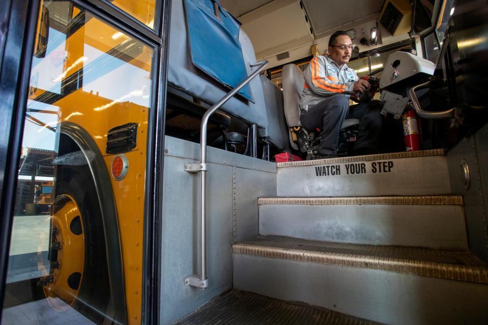 Coachella Valley Unified School District mechanic Rick Herrera fixes the dashboard on a school bus at the transportation facility in Thermal, Calif., on July 18, 2022. 