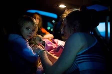 Fort McMurray resident Crystal Maltais buckles in her daughter, Mckennah Stapley, as they prepare to leave Conklin, Alberta, for Lac La Biche after evacuating their home in Fort McMurray on Tuesday May 3, 2016. REUTERS/Topher Seguin