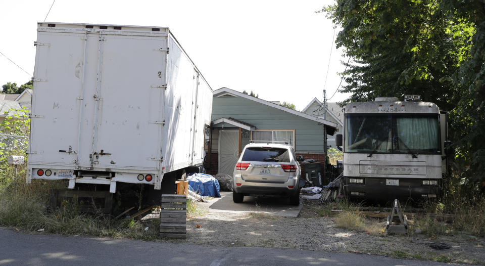 Vehicles are parked outside the home of Paige A. Thompson, who uses the online handle "erratic," Wednesday, July 31, 2019, in Seattle. Thompson was taken into custody Monday at her home and has been charged with computer fraud and abuse in connection with hacking data from more than 100 million Capital One credit holders or applicants. (AP Photo/Ted S. Warren)