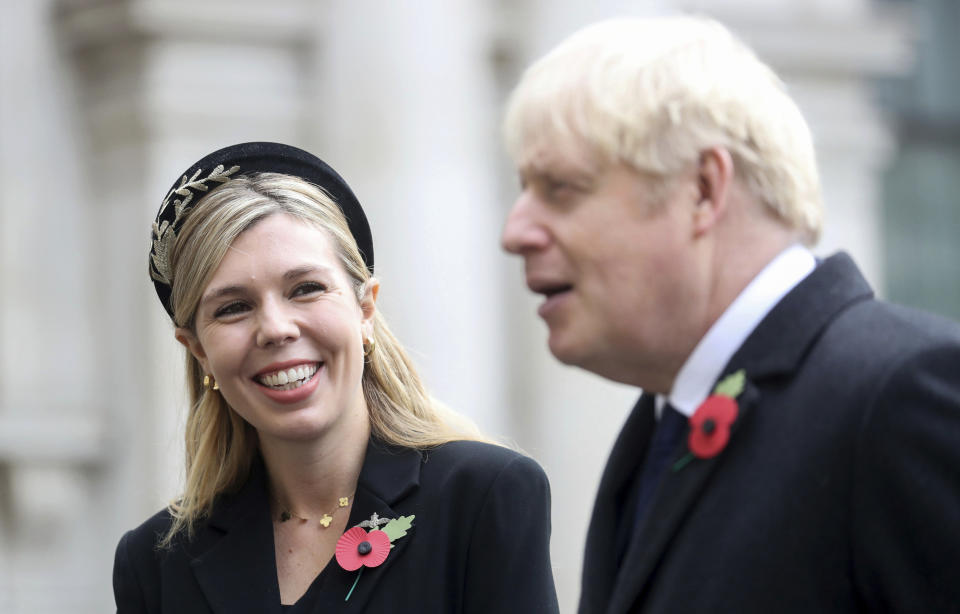 Britain's Prime Minister Boris Johnson, right, with partner Carrie Symonds, talk with veterans following the Remembrance Sunday service at the Cenotaph, in Whitehall, London, Sunday Nov. 8, 2020. (Chris Jackson/Pool Photo via AP)