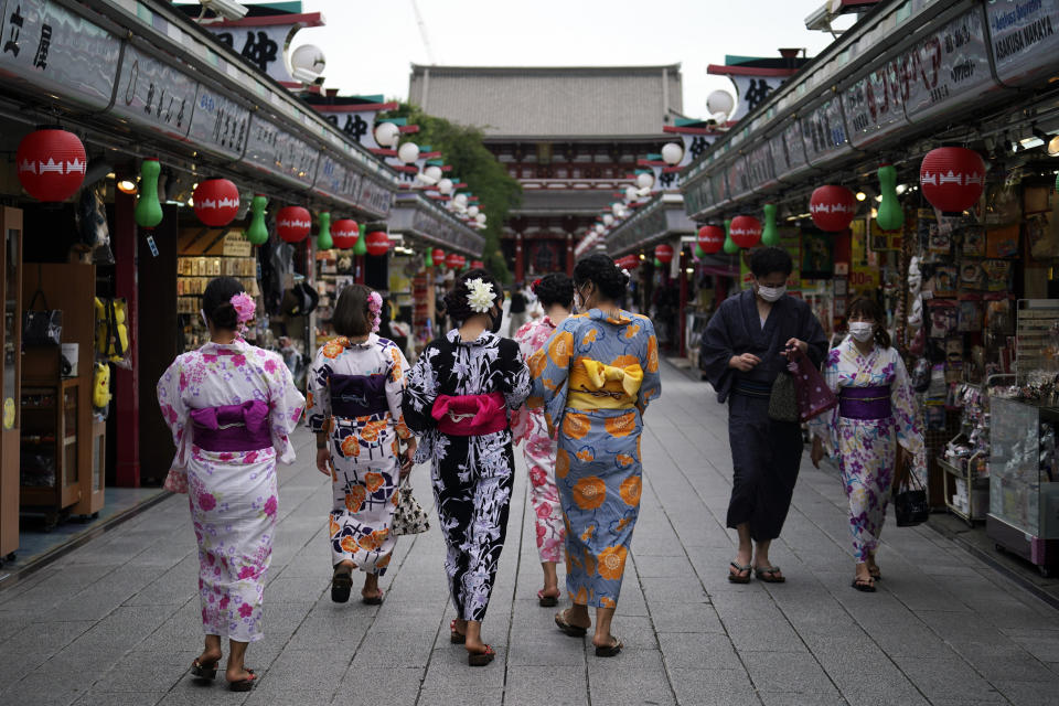 Tourists in traditional Japanese kimonos walk in Asakusa district in Tokyo Monday, July 27, 2020. The Japanese capital confirmed Monday more than 100 new coronavirus cases. (AP Photo/Eugene Hoshiko)