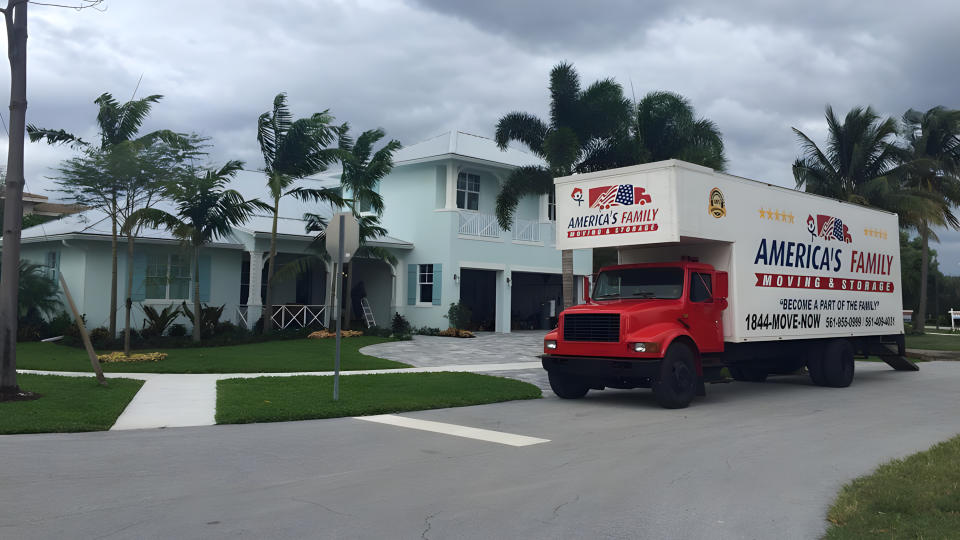 An America's Family Moving & Storage truck sits outside of a house
