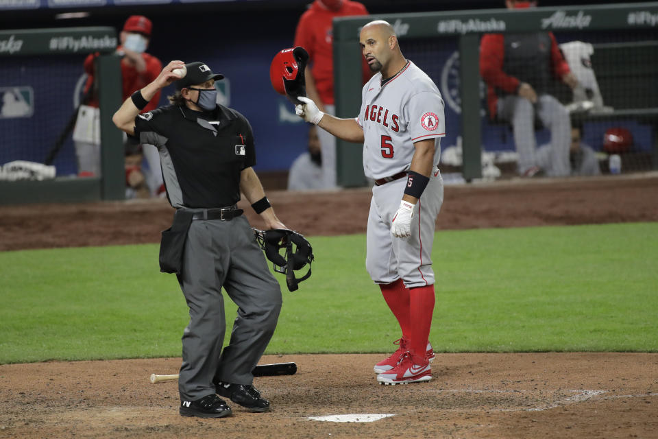 Los Angeles Angels' Albert Pujols (5) looks at home plate umpire Chris Guccione after he was called out on strikes looking to end the top of the eighth inning of the team's baseball game against the Seattle Mariners, Tuesday, Aug. 4, 2020, in Seattle. (AP Photo/Ted S. Warren)