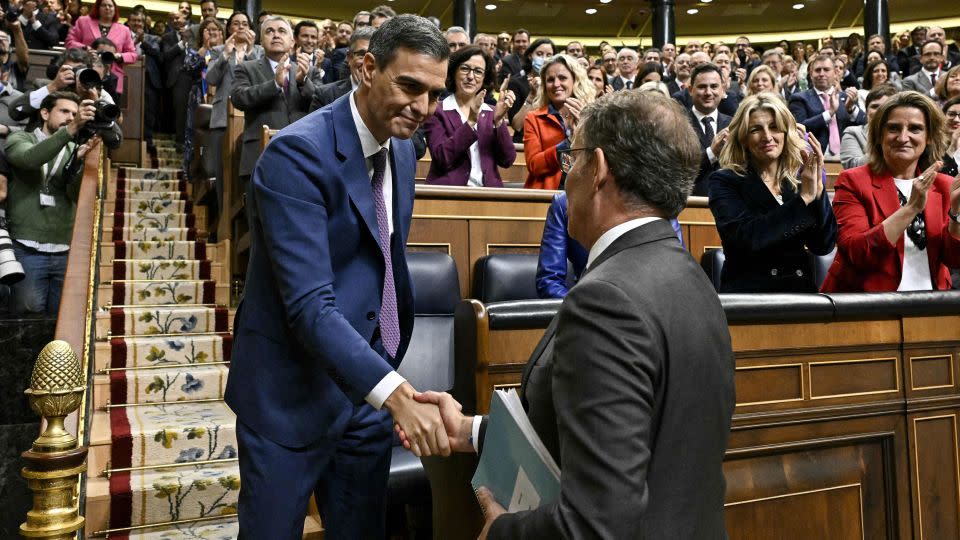 Pedro Sanchez (L) is congratulated by Partido Popular leader Alberto Nunez Feijoo after winning a parliamentary vote to elect Spain's next premier, at the Congress of Deputies in Madrid on November 16. - Javier Soriano/Pool/AFP/Getty Images