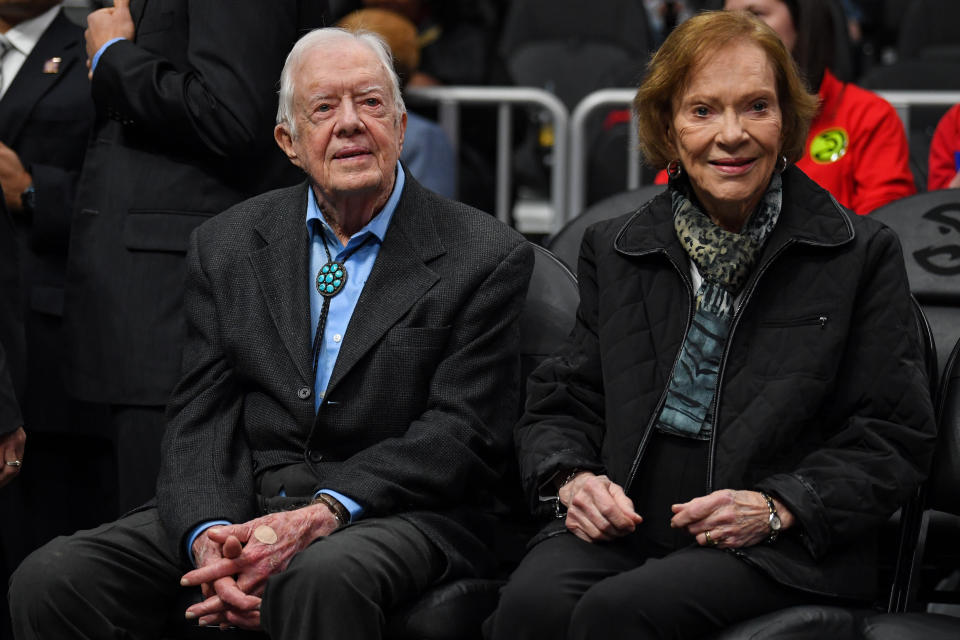 Jimmy and Rosalynn Carter sit in the stands at a basketball game.