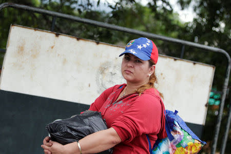 A woman holds her luggage as she tries to cross into Colombia from Venezuela through the Simon Bolivar international bridge in Cucuta, Colombia August 8, 2018. REUTERS/Luisa Gonzalez