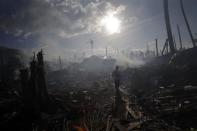 A man walks through smoke from fires in a part of Tolosa devastated by Typhoon Haiyan, November 16, 2013. Long-delayed emergency supplies flowed into the typhoon-ravaged central Philippines on Saturday, reaching desperate families who had to fend for themselves for days, as the United Nations more than doubled its estimate of homeless to nearly two million. REUTERS/John Javellana