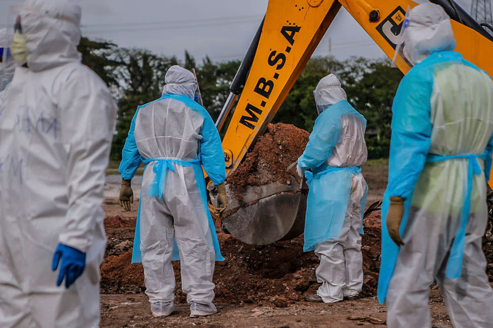 Health workers in personal protective equipment bury the body of a Covid-19 victim at the Muslim cemetery in Section 21, Shah Alam July 10, 2021. ― Picture by Hari Anggara