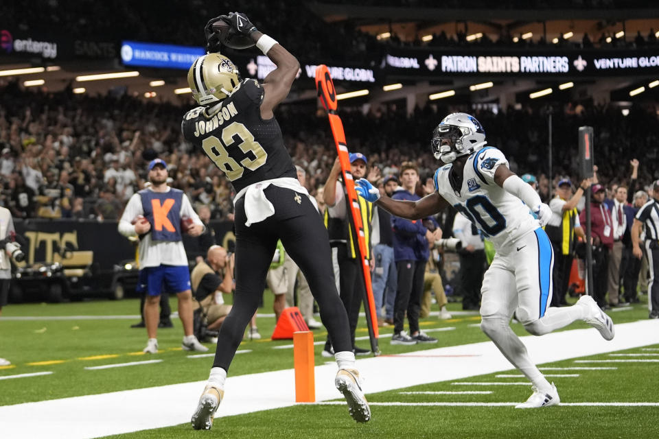 New Orleans Saints tight end Juwan Johnson (83) makes a touchdown catch in the end zone past Carolina Panthers safety Jordan Fuller, right, during the first half of an NFL football game Sunday, Sept. 8, 2024, in New Orleans. (AP Photo/Gerald Herbert)