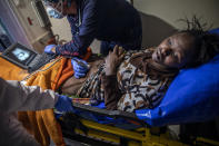 16-year old Sita Yakita from Guinea Conakry lies in the infirmary while Juanfe, the doctor on board the Spanish NGO Open Arms vessel performs an ultrasound scan to see her unborn child after being rescued in the Mediterranean Sea, international waters, Sunday Feb.14, 2021. Various African migrants drifting in the Mediterranean Sea after fleeing Libya on unseaworthy boats have been rescued. In recent days, the Libyans had already thwarted eight rescue attempts by the Open Arms, a Spanish NGO vessel, harassing and threatening its crew in international waters. (AP Photo/Bruno Thevenin)