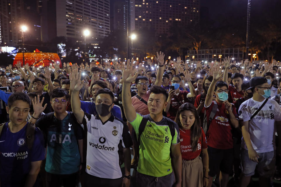 Pro-democracy football fans gather to form a human chain as they sing songs at Victoria Park in Hong Kong, Wednesday, Sept. 18, 2019. An annual fireworks display in Hong Kong marking China's National Day on Oct. 1 was called off Wednesday as pro-democracy protests show no sign of ending. (AP Photo/Kin Cheung)