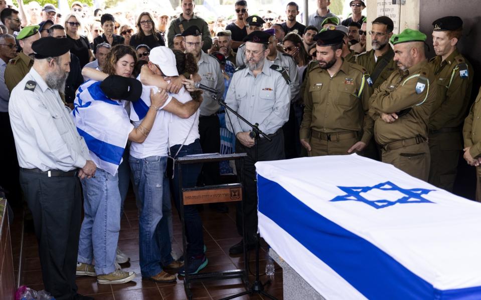 Family members and friends embrace during the service