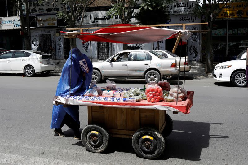 FILE PHOTO: An Afghan woman pushes her cart in Kabul