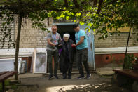 A woman is evacuated by volunteers of Vostok SOS charitable organisation in Kramatorsk, eastern Ukraine, Thursday, May 26, 2022. Residents in villages and towns near the front line continue to flee as fighting rages in eastern Ukraine. (AP Photo/Francisco Seco)