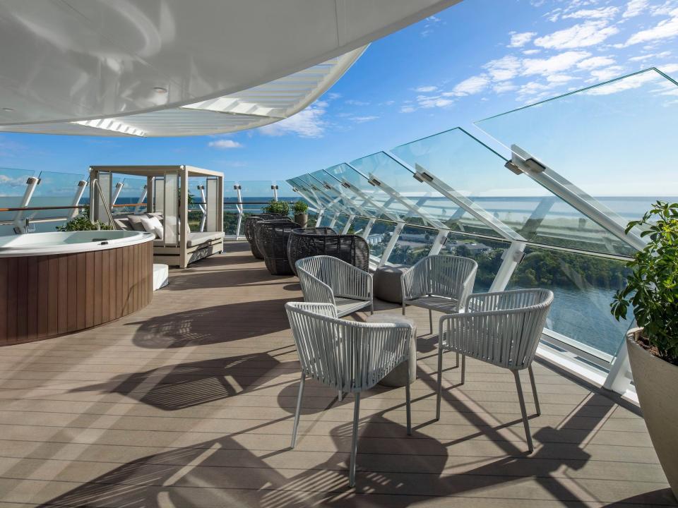 the outdoor balcony with lounge seating, a hot tub, and cabana in the Iconic suite aboard the Celebrity Apex cruise ship