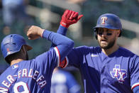 Texas Rangers' Joey Gallo, right, celebrates with Isiah Kiner-Falefa after hitting a two-run home run during the first inning of a spring training baseball game against the Kansas City Royals, Sunday, Feb. 28, 2021, in Surprise, Ariz. (AP Photo/Charlie Riedel)